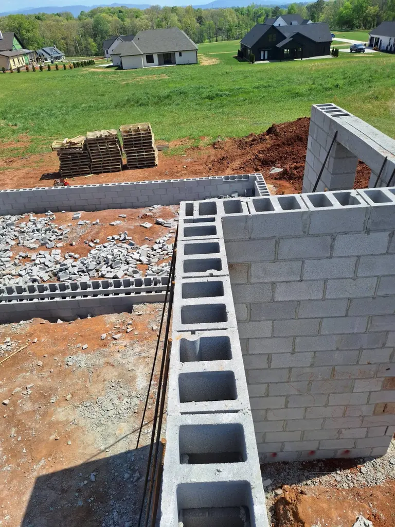 Block retaining wall going up with drainage stone at its base in Knoxville, Tennessee