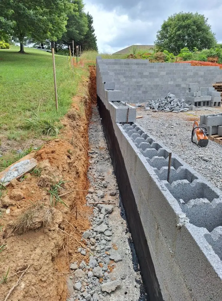 Drainage stone backfilled along a new block retaining wall in Knoxville, Tennessee