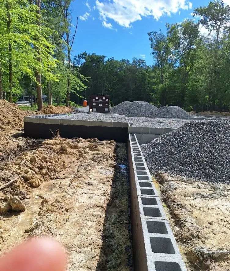 First course of block set in the trench for a long retaining wall in Knoxville, Tennessee