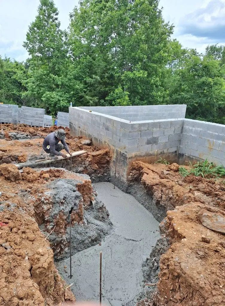 Fresh concrete footing poured for a block retaining wall in Knoxville, Tennessee
