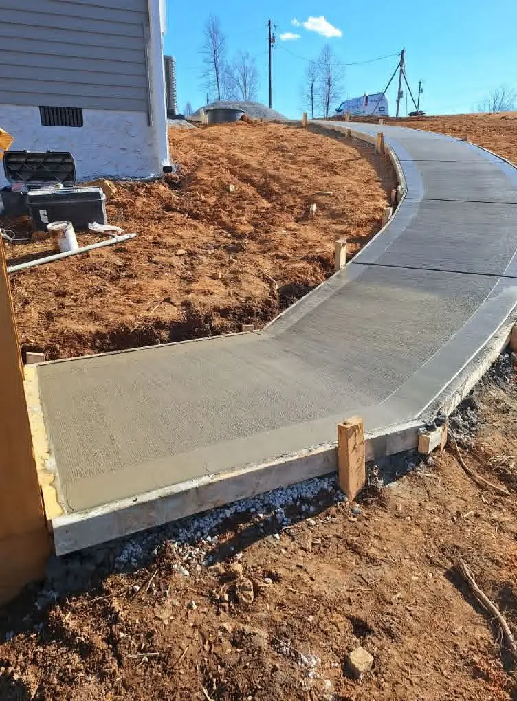 Fresh concrete walkway poured on a sloped yard in Knoxville, Tennessee